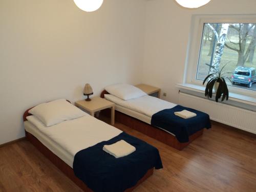 2 camas en una habitación pequeña con ventana en Apartamenty Nad Odra, en Wroclaw