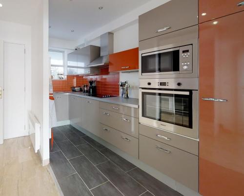 une cuisine avec des appareils électroménagers en acier inoxydable et des oranges dans l'établissement Marina Riviera Sea View and Beach, à Villeneuve-Loubet