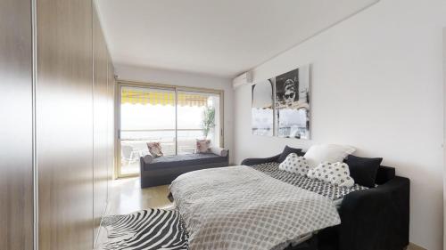 une chambre avec un lit et une pièce avec une fenêtre dans l'établissement Marina Riviera Sea View and Beach, à Villeneuve-Loubet