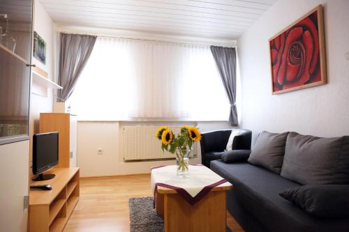 een woonkamer met een bank en een vaas met bloemen op een tafel bij Ferienwohnung Langenhecke 16 in Bad Münstereifel
