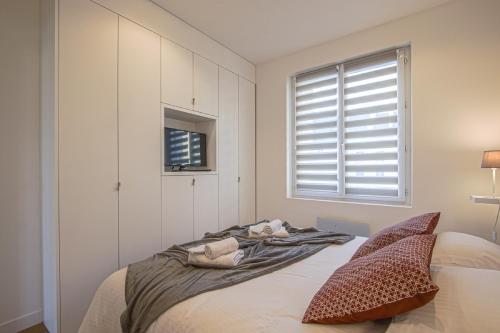 a bedroom with a bed with two pillows and a window at Port de Caen Haut de Gamme in Caen