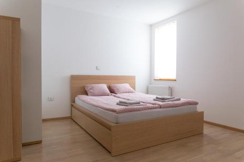 1 dormitorio con cama con sábanas rosas y ventana en Auredius Deluxe Apartment en Kranjska Gora