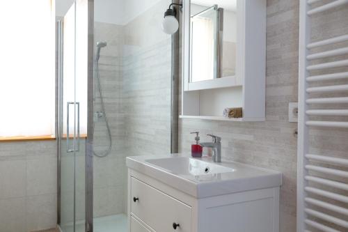 y baño blanco con lavabo y ducha. en Auredius Deluxe Apartment en Kranjska Gora