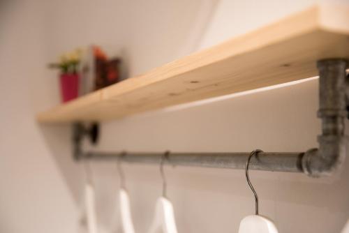 a wooden shelf on a wall with a pipe at 框框背包客棧 Kuang Kuang Hostel in Longjing