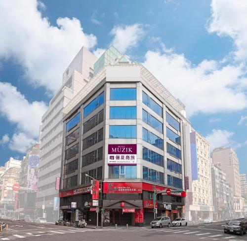 a large white building with a sign on it at Muzik Hotel - Ximending Xining Branch in Taipei