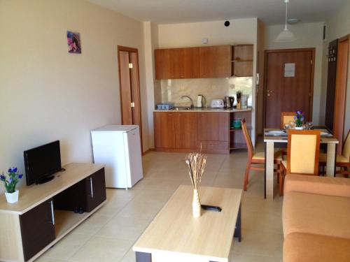 a kitchen and living room with a table and a refrigerator at PSB Apartments in Midia Resort Aheloy in Aheloy