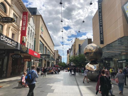 a crowd of people walking down a shopping street at Lux 2BR Apt on Hindmarsh SQ-Pool-Gym-Sauna-Parking in Adelaide