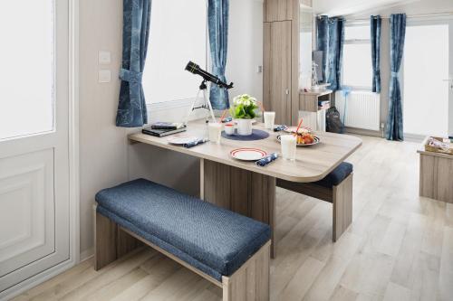 a dining room table with a blue seat and a table at Coed Helen Holiday Park in Caernarfon