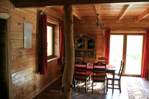 ein Esszimmer mit einem Tisch und Stühlen in einer Hütte in der Unterkunft Noclegi Urbaniak in Tylmanowa