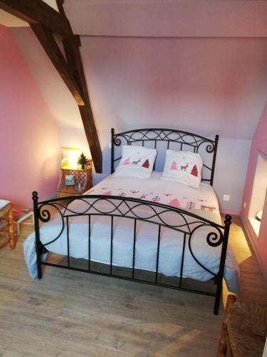 - une chambre dotée d'un lit noir avec des draps et des oreillers blancs dans l'établissement Au Petit Jardin, à Cassel