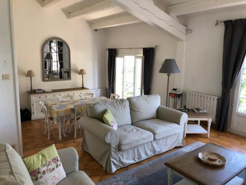 ein Wohnzimmer mit einem Sofa und einem Tisch in der Unterkunft Villa with private pool and lake view in Narbonne