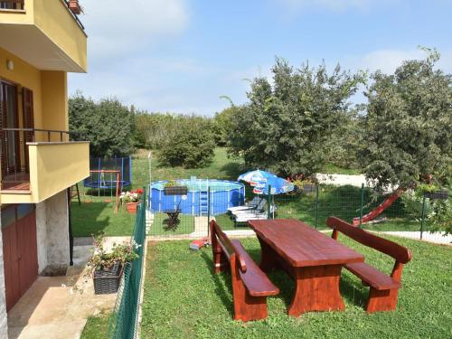 a picnic table and benches next to a playground at Premium Apartment in Barban with Private Pool in Šajini
