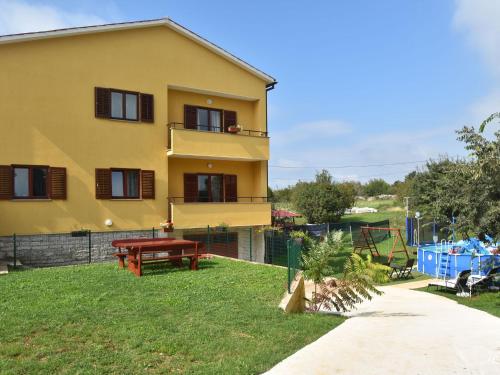 a yellow house with a picnic table and a playground at Premium Apartment in Barban with Private Pool in Šajini