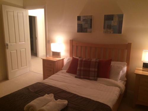 a bedroom with a bed and two lamps and a door at ArdMullen Townhouse X Davitt's Guesthouse & Restaurant Kenmare in Kenmare