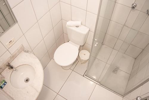 a small bathroom with a toilet and a shower at Plaza Hotel São José dos Campos in São José dos Campos