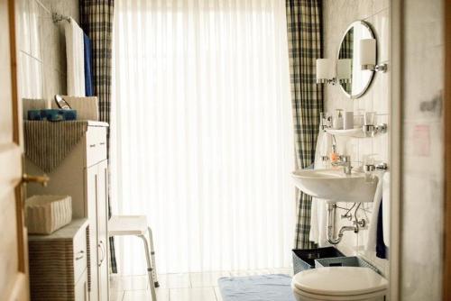 a bathroom with a sink and a toilet and a mirror at Bulemanns Haus in Husum