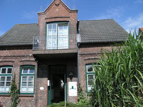 ein Backsteinhaus mit Balkon darüber in der Unterkunft Bulemanns Haus in Husum