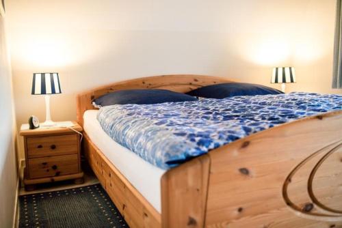 a bedroom with a wooden bed and a nightstand with two lamps at Bulemanns Haus in Husum