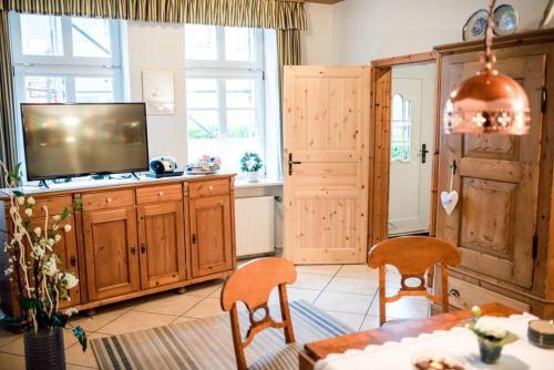 a living room with a television and a table and chairs at Bulemanns Haus in Husum