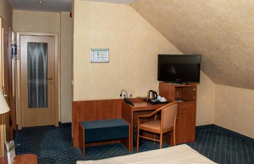 a hotel room with a desk and a television at Kiek In Hotel Zur Einkehr in Stade