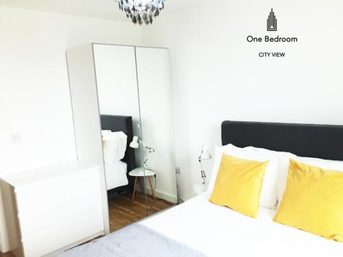 a bedroom with a white bed with yellow pillows at Media City Salford Quays in Manchester