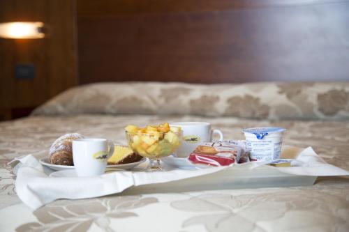 a table with a tray of food on a bed at Hotel Metropole in Rimini