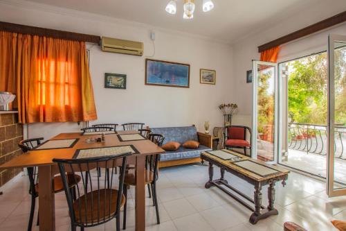 ein Wohnzimmer mit Tisch, Stühlen und Sofa in der Unterkunft Dennis Tsilivi Houses & Studios by "elite" in Planos
