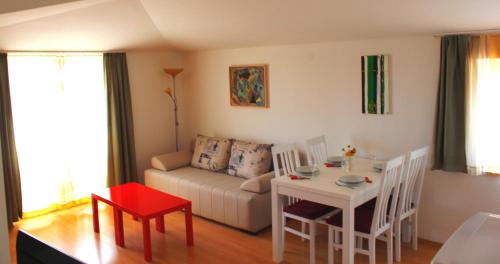 ein Wohnzimmer mit einem Tisch und einem Sofa in der Unterkunft Mladen in Fažana