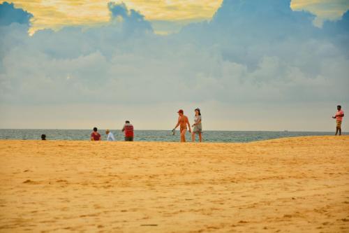 a group of people standing on a beach at Oriental Rest in Hikkaduwa