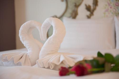 two white swans shaped like hearts sitting on a bed at Elizabeth Hotel in Taichung