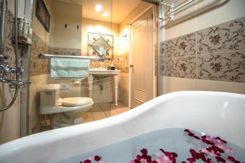 a bathroom with a bath tub and a toilet at Elizabeth Hotel in Taichung