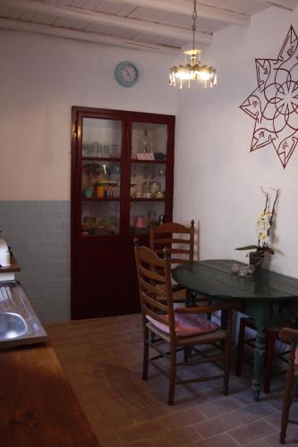 a kitchen with a table and chairs and a clock on the wall at Silves Historical House in Silves