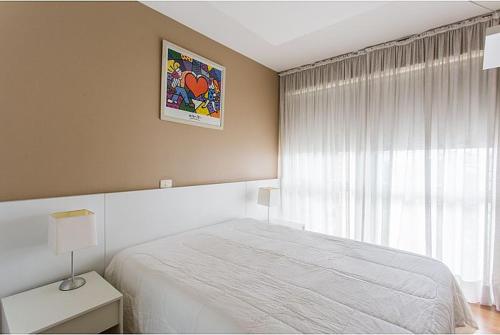 - une chambre avec un lit blanc et une fenêtre dans l'établissement Duplex NYC Berrini 2 dormitórios - ao lado do WTC, à São Paulo