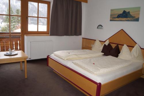 a bedroom with a bed with a wooden headboard at Pension Strolz in Sankt Anton am Arlberg