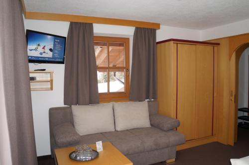 a living room with a couch and a window at Pension Strolz in Sankt Anton am Arlberg