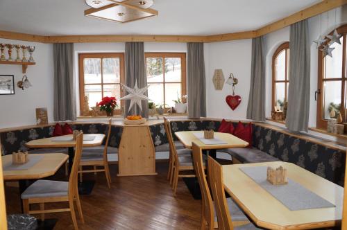 a restaurant with tables and chairs and windows at Pension Strolz in Sankt Anton am Arlberg