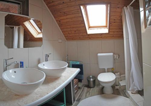 a bathroom with two sinks and a toilet at Pension Elisabeth in Balatonlelle