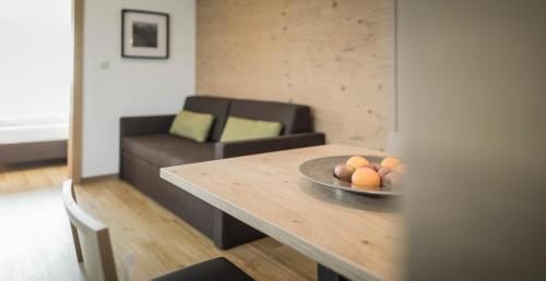 a living room with a table with a bowl of fruit on it at Residence Margareth in Campo Tures