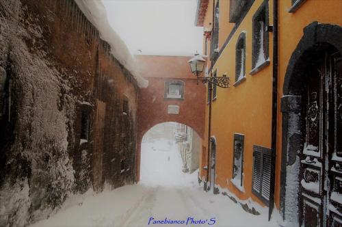 an alley with snow on the ground in a city at L'Arco dei Sogni in Malvagna
