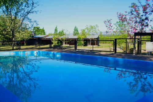 una piscina con valla y una casa en La Argentina Complejo en Villa Ciudad de América