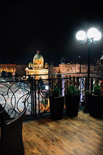 a balcony with a view of a city at night at President Lux in Belgrade