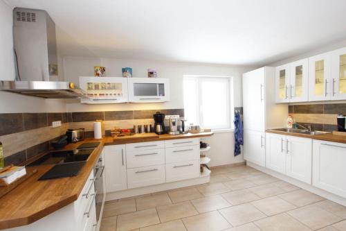 a kitchen with white cabinets and white appliances at Villa Maximus in Jáchymov
