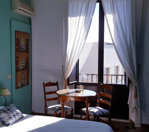 a bedroom with a table and chairs and a window at Villa Floresta Taormina in Taormina