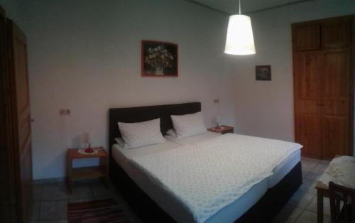 a bedroom with a bed with white sheets and a light at Ferienwohnung Jüngling in Neumagen-Dhron