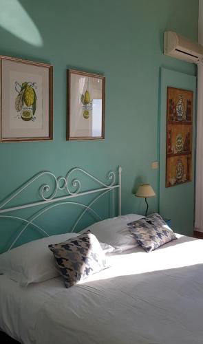 a bed in a bedroom with blue walls at Villa Floresta Taormina in Taormina