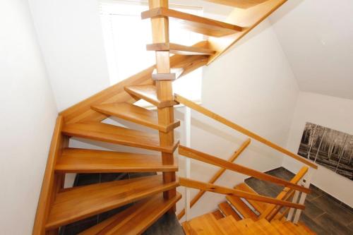 a wooden spiral staircase in a room with white walls at Villa Maximus in Jáchymov
