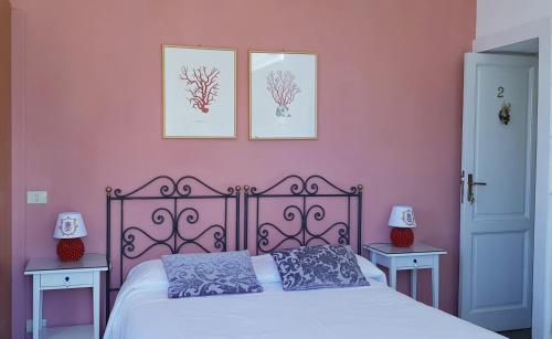 a bedroom with a bed and two pictures on the wall at Villa Floresta Taormina in Taormina