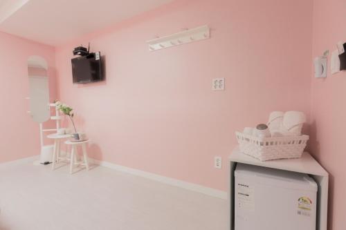 a room with pink walls and a tv at MJ Stay 2 in Seoul