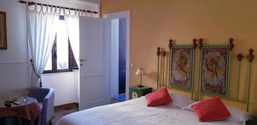 a bedroom with a bed with red pillows on it at Villa Floresta Taormina in Taormina