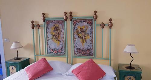 a bed with two pink pillows on top of it at Villa Floresta Taormina in Taormina